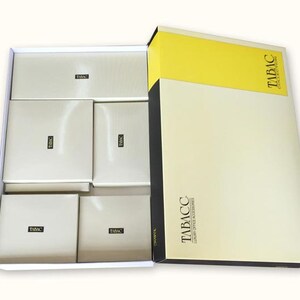 May include: A white box with six smaller boxes inside. The smaller boxes are all white with the word "TABACC" printed on them. The larger box is yellow and white with the text "TABACC" printed on it.