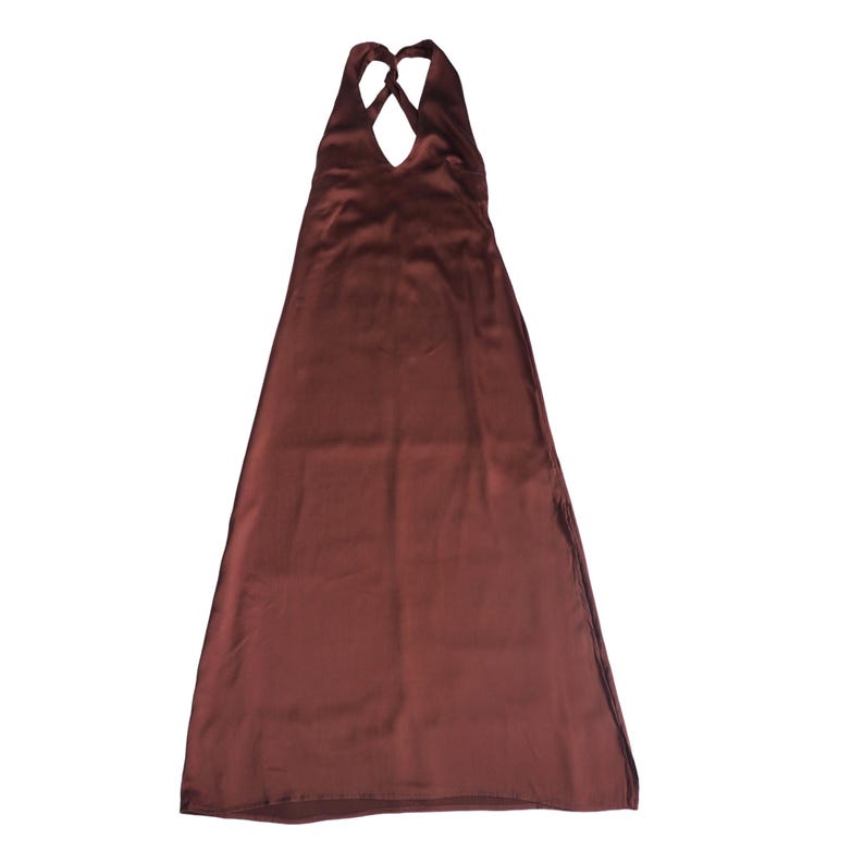 May include: A floor-length, solid dark brown satin dress featuring a halter neckline with crisscross straps at the top. The garment has a smooth, reflective finish and a simple, flowing A-line silhouette that extends down to the hemline.