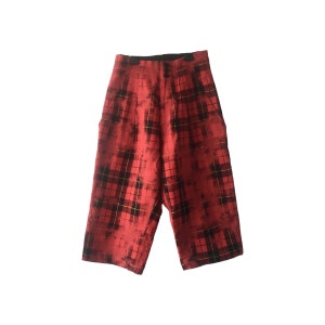 Könnte beinhalten: Rote und schwarze karierte Shorts mit einem verblassten Look. Die Shorts haben eine weite Beinweite und eine hohe Taille.