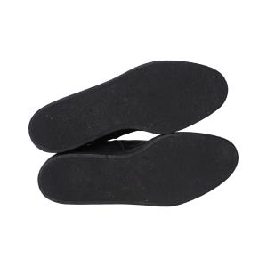 May include: A pair of black shoes shown from the bottom view, featuring flat, solid black rubber outsoles with a smooth, uniform texture. The soles are oval-shaped and lack any visible tread patterns, logos, or markings on the surface.
