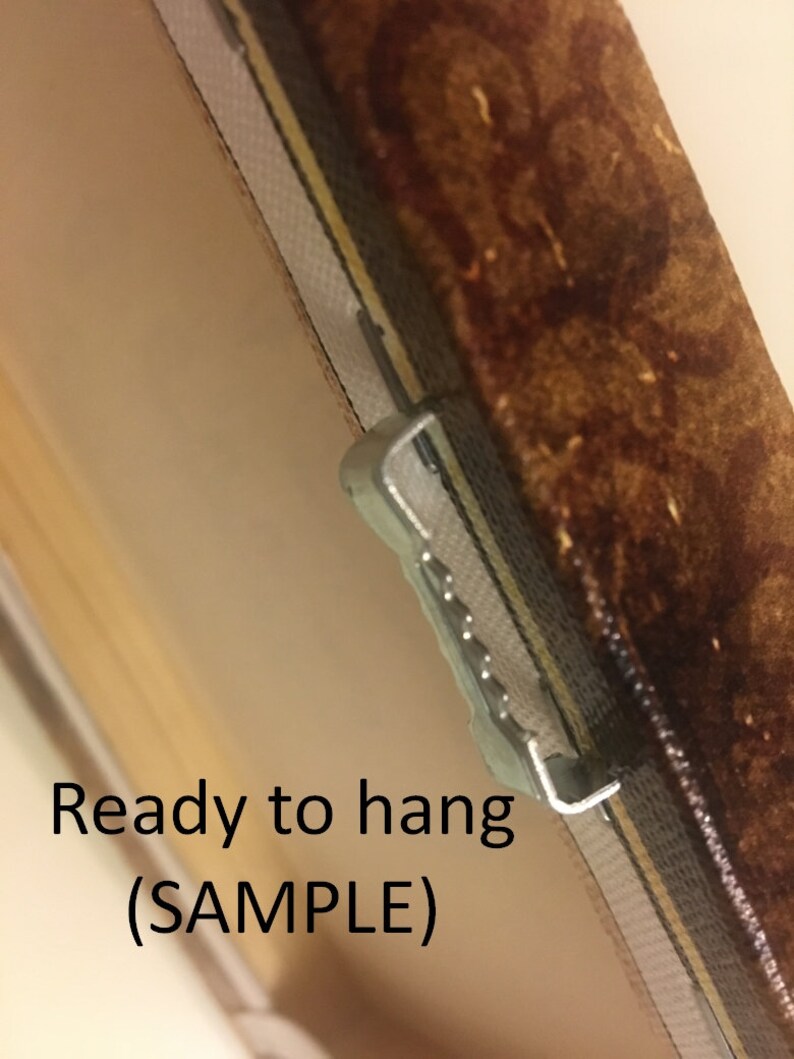 May include: Close-up of a brown canvas painting with a metal hanging hook attached to the back. The text "Ready to hang (SAMPLE)" is printed on the canvas.
