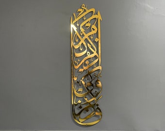 Op de afbeelding: Gouden metalen wandkunst met ingewikkelde Arabische kalligrafie. Het ontwerp is een verticale rechthoek met een decoratieve rand.