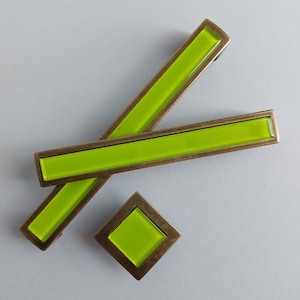 Op de afbeelding: Set van drie limoengroene glazen kastknoppen met antieke messing frames. De knoppen zijn rechthoekig en vierkant.