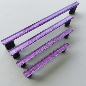 Fired glass cabinet pulls in sparkly purple made of fine glass sticks attached over a metal base. Slightly textured glass furniture handles with rounded edges.