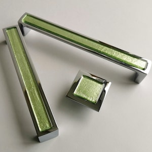 May include: Three cabinet pulls with a chrome finish and a light green glass insert. The pulls are in different sizes, with the largest being approximately 25 cm long.