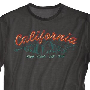 May include: A black t-shirt with a graphic print of a mountain range and the text "California" in red and orange. The text below the graphic reads "Walk - Climb - Get - Lost."