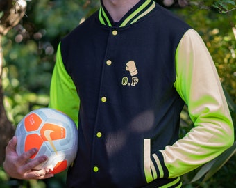 May include: A black and neon green varsity jacket with a yellow embroidered boxing glove and the letters "O.P." on the chest. The jacket has a zipper closure and a ribbed collar, cuffs, and waistband.