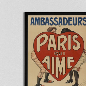 May include: A vintage poster advertising the Ambassadors in Paris. The poster features a red heart with the words "Paris Qui Aime" in white lettering. A man and woman are standing behind the heart, with their arms around each other.