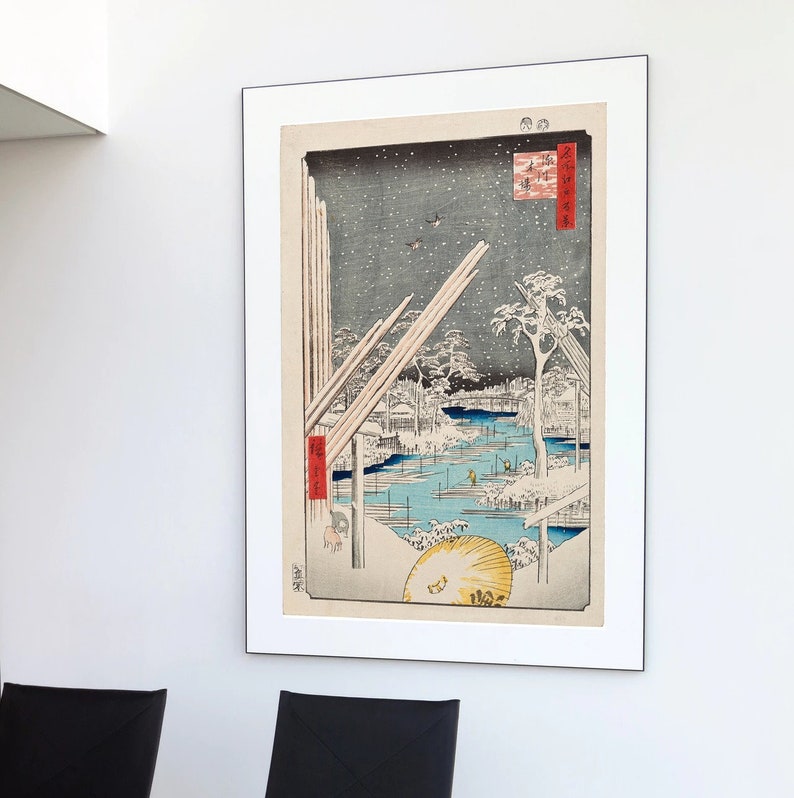 May include: A vintage Japanese woodblock print depicting a snowy winter scene with a river, trees, and a few figures. The print is framed in a white mat and a black frame.