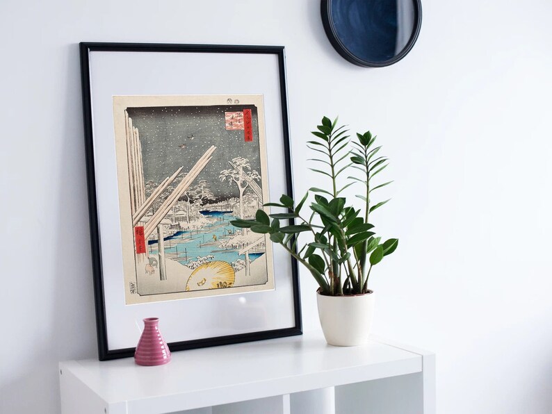 May include: A framed black and white print of a Japanese woodblock print depicting a snowy landscape with a bridge and buildings. The print is titled "Atsu", and the artist's signature is visible in the lower right corner.