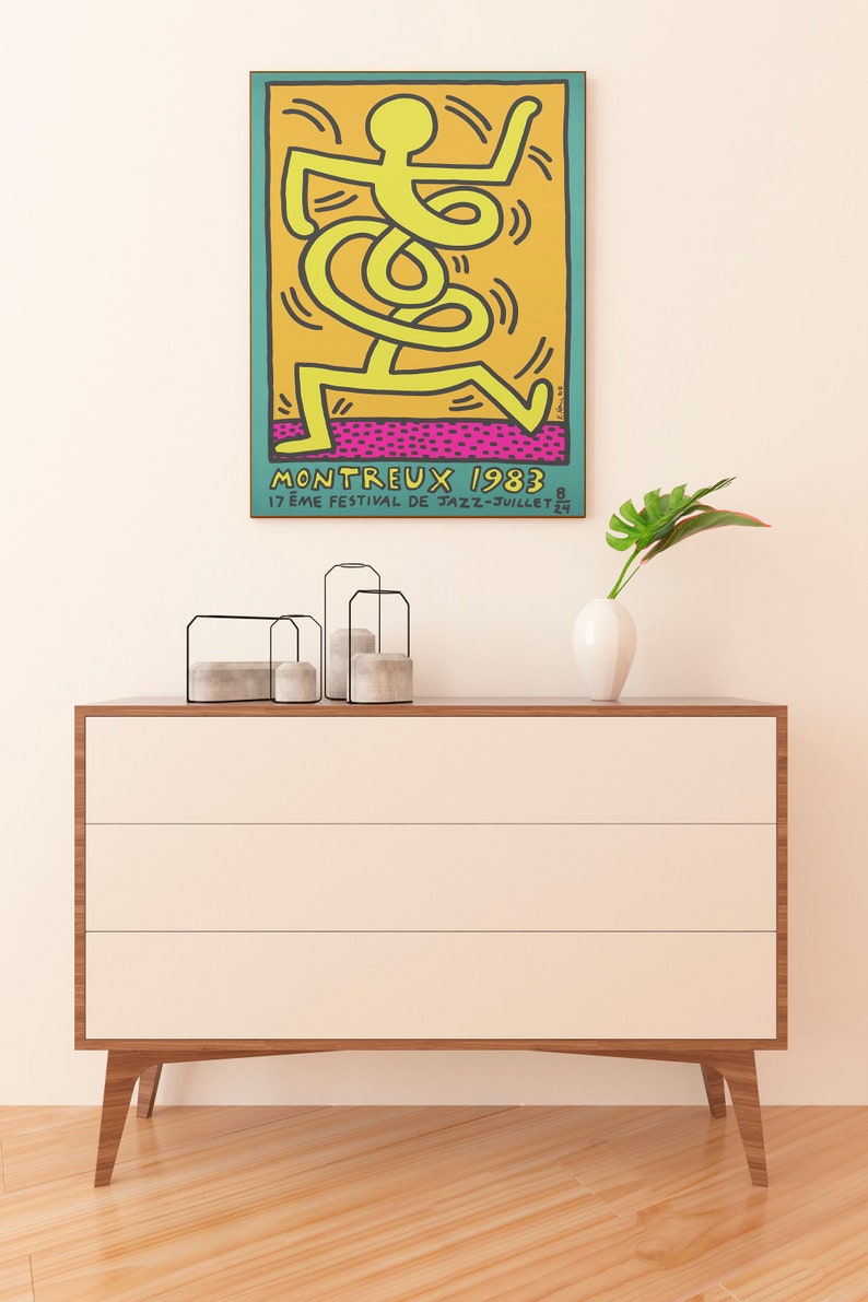 K&ouml;nnte beinhalten: Ein Vintage-Poster f&uuml;r das Montreux Jazz Festival 1983 mit einer gelben Strichm&auml;nnchenfigur, die auf einem rosa und orangefarbenen Hintergrund tanzt. Der Text auf dem Poster lautet "Montreux 1983 17&egrave;me Festival de Jazz - Juillet 24"