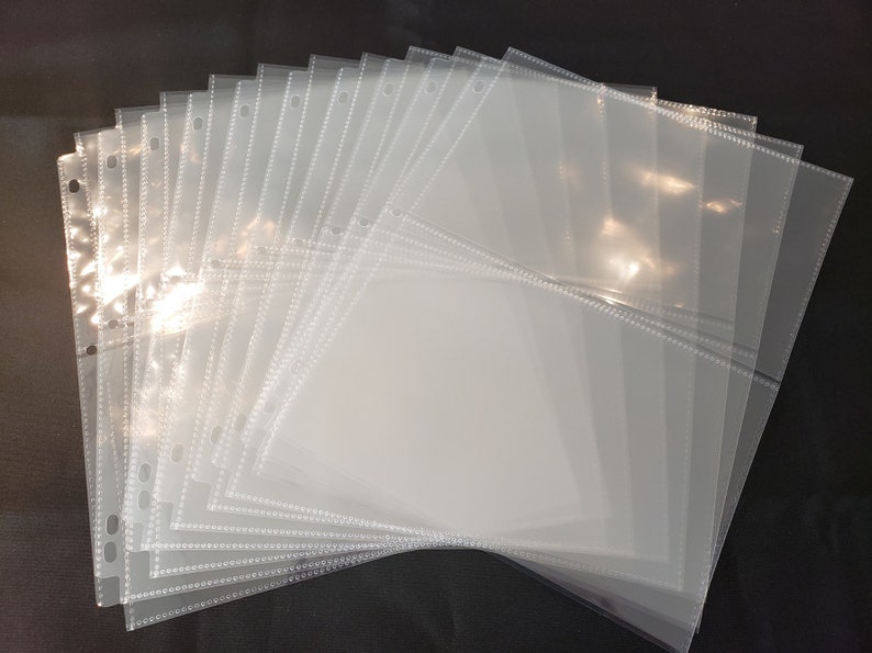 May include: A stack of clear plastic sleeves with holes for a binder. The sleeves have a dotted border and are designed to hold and protect photos, cards, or other paper items.