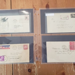 May include: Four envelopes with stamps and handwritten addresses. The envelopes are in a black album with clear plastic sleeves. The stamps are from different years and feature different designs. The envelopes are addressed to different people and places.