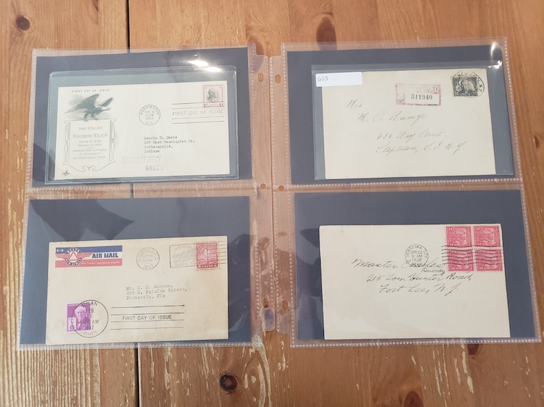 May include: Four envelopes with stamps and handwritten addresses. The envelopes are in a black album with clear plastic sleeves. The stamps are from different years and feature different designs. The envelopes are addressed to different people and places.
