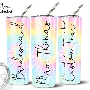 May include: Three stainless steel tumblers with lids and straws. The tumblers have a tie-dye pattern in shades of pink, blue, and yellow. The text on the tumblers reads "Bridemaid", "Mrs. Thomas", and "Custom Text".
