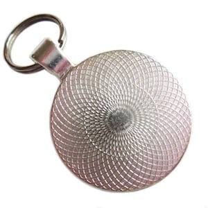 Puede incluir: Llavero de plata con un dije redondo de plata. El dije tiene un patr&oacute;n circular texturizado.