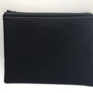 May include: A black zippered pouch with a white zipper and white stitching.