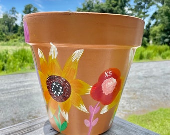 Esta maceta de flores de terracota de 8" pintada a mano con flores silvestres