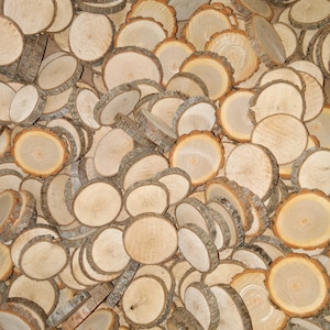 May include: A large pile of natural wood slices, each with a different grain pattern and bark edge. The wood slices are various sizes and shapes, and they are all arranged in a random pattern.