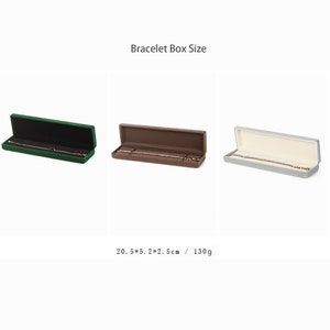 May include: Three velvet-lined jewelry boxes in green, brown, and gray. Each box is open and contains a bracelet. The boxes measure 20.5 x 5.2 x 2.5 cm and weigh 130 grams.