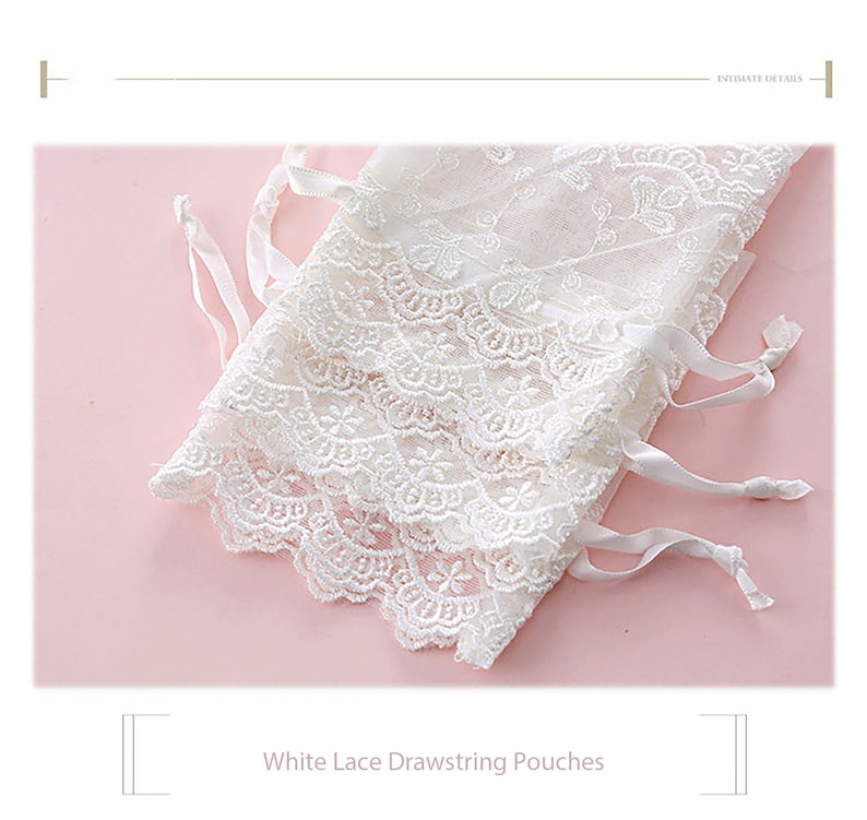 May include: White lace drawstring pouches with delicate floral embroidery and white satin ribbon ties.