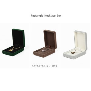 May include: Three velvet jewelry boxes in green, brown, and gray, each with a necklace inside. The boxes are 7 inches by 9 inches by 3.5 inches and weigh 100 grams.