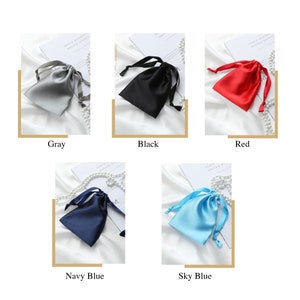 May include: Five small satin drawstring bags in different colors: gray, black, red, navy blue, and sky blue. The bags are arranged in a grid pattern on a white surface.