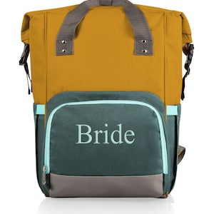 Puede incluir: Una mochila mostaza y verde azulado con la palabra "Bride" bordada en la parte delantera. La mochila tiene un asa y correas grises, una cremallera verde azulado y un panel inferior gris. Cuenta con un diseño enrollable con hebillas laterales.