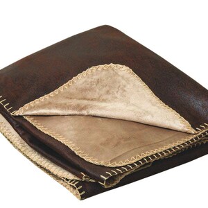 May include: A brown faux suede throw blanket with a tan faux fur lining. The blanket has a decorative stitched edge.