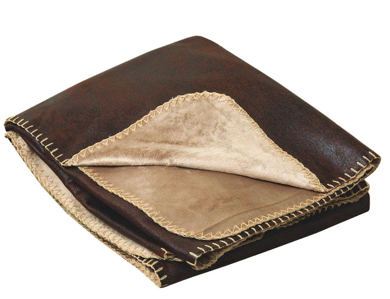 May include: A brown faux suede throw blanket with a tan faux fur lining. The blanket has a decorative stitched edge.