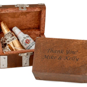 May include: A wooden treasure chest with a hinged lid, open to reveal two miniature bottles of liquor. The chest is engraved with the text "Thank You! Mike & Kelly".