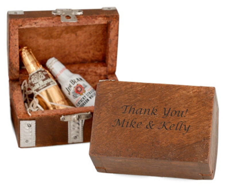 May include: A wooden treasure chest with a hinged lid, open to reveal two miniature bottles of liquor. The chest is engraved with the text "Thank You! Mike & Kelly".