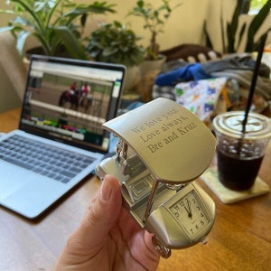 May include: A silver golf cart clock with a personalized message that reads "We love you! Love always, Bre and Kruz".