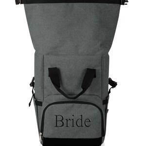 May include: Gray and black insulated backpack with a zippered top and a front pocket that says "Bride".