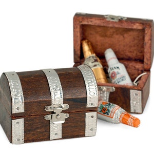 May include: Two wooden treasure chests with silver accents. The larger chest is open and contains miniature bottles of liquor. The smaller chest is closed.