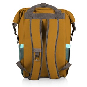 May include: Mustard-coloured backpack with grey straps and accents. Features a teal side pocket and a built-in bottle opener. The backpack has a top handle and adjustable shoulder straps. The brand logo is visible on the back.