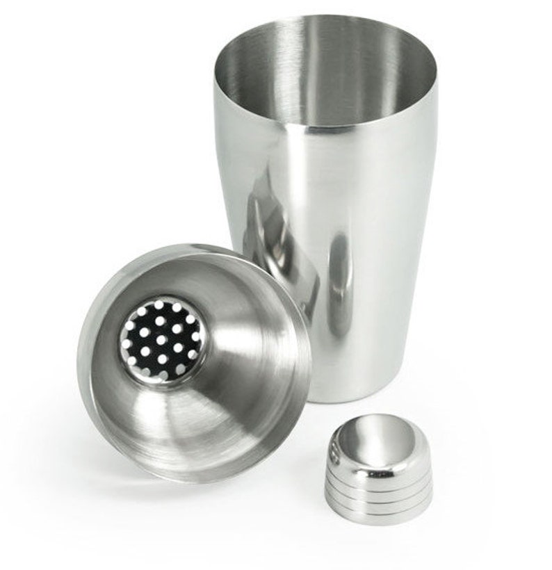 May include: A stainless steel cocktail shaker with a strainer lid and a separate cap. The shaker has a smooth, polished finish.