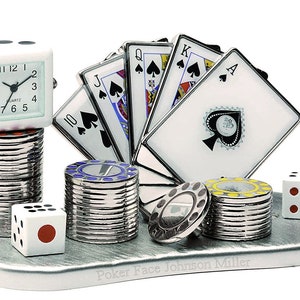 May include: A silver desk organizer with a clock, dice, poker chips, and playing cards. The cards are all spades and include the 10, Jack, Queen, King, and Ace. The text "Poker Face Johnson Miller" is engraved on the base.