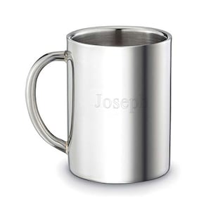 May include: A silver stainless steel mug with a handle. The mug has the name "Joseph" engraved on the front.