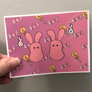 Op de afbeelding: Roze konijnenillustratie met snoep- en lollyontwerpen op een roze achtergrond.