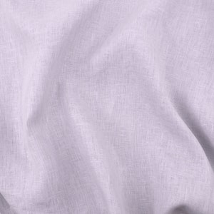 May include: A close-up of a light purple linen fabric with a textured weave. The fabric is wrinkled and has a soft, natural look.