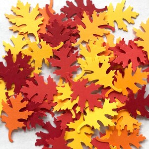 May include: A collection of fall-themed paper leaves in shades of orange, yellow, and red. The leaves are cut in a simple, classic shape and are perfect for crafting or decorating.