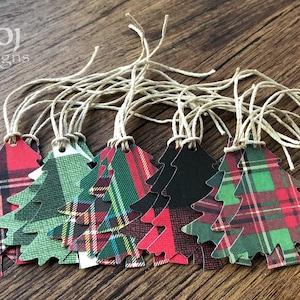 May include: A set of ten Christmas tree gift tags with a plaid design in red, green, and black. The tags are made of paper and have a twine string attached.