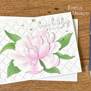 May include: A white card with a pink flower and green leaves. The card has a diamond pattern and the text "happy birthday to you".