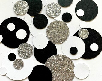 May include: Black and silver confetti circles. The circles are various sizes and have a glittery finish.