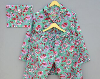 May include: A green and pink floral print pyjama set with a long-sleeved top and matching trousers. The set includes a small envelope-style pocket.