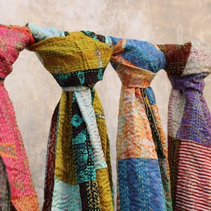 May include: Five colourful kantha scarves with intricate stitching and patchwork designs. The scarves are made from recycled saris and are a popular choice for home decor and fashion accessories.