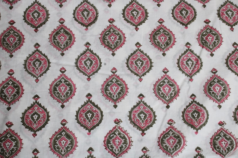 May include: White fabric featuring a repeating pattern of pink, dark green, and grey teardrop shapes. The design is symmetrical and ornate, with each shape containing interior details.