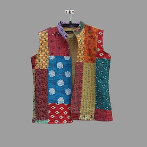 May include: A sleeveless patchwork vest with a mandarin collar. The vest is made of different fabrics with floral and geometric patterns in shades of red, blue, green, yellow, and orange.