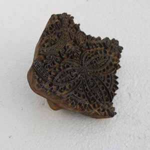 May include: A wooden block printing stamp with a detailed floral design. The stamp is carved with intricate patterns and is ready to be used for textile printing.